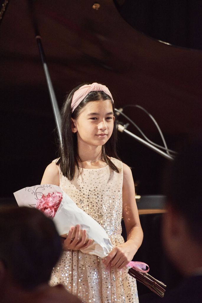 Student has a flowers after performance - K&M Music School Piano Lessons for Kids and Adults in San Diego