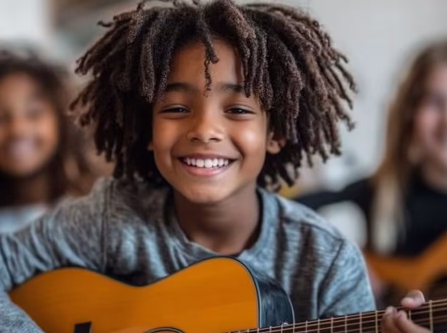 Group of young guitar learners collaborating during a music lesson at K&M Music School