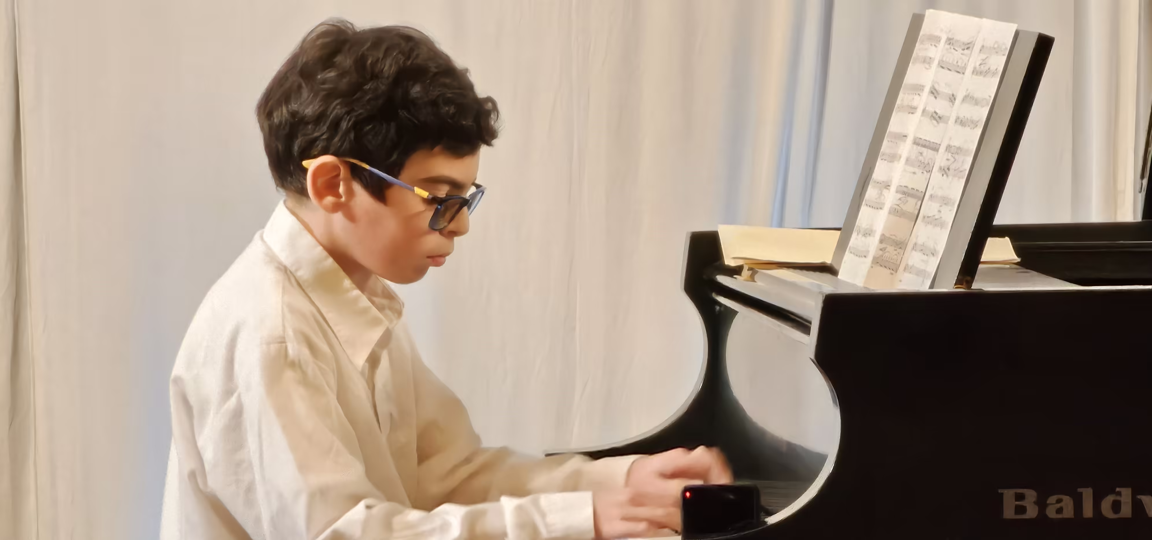 Young piano student concentrating during lesson
