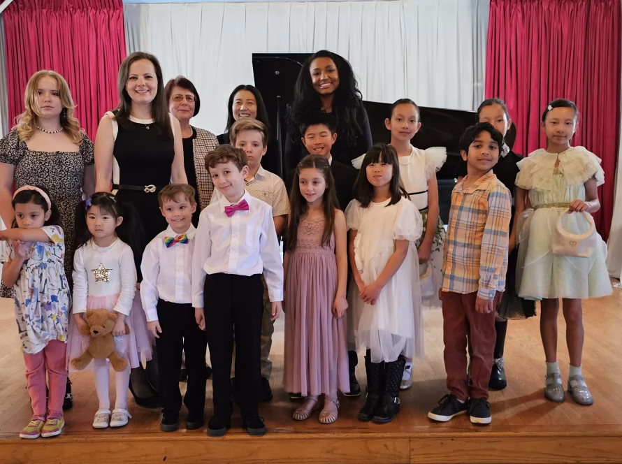 Students and teachers of K&M Music School gather on stage after a community recital, highlighting San Diego's accessible non-profit music education.