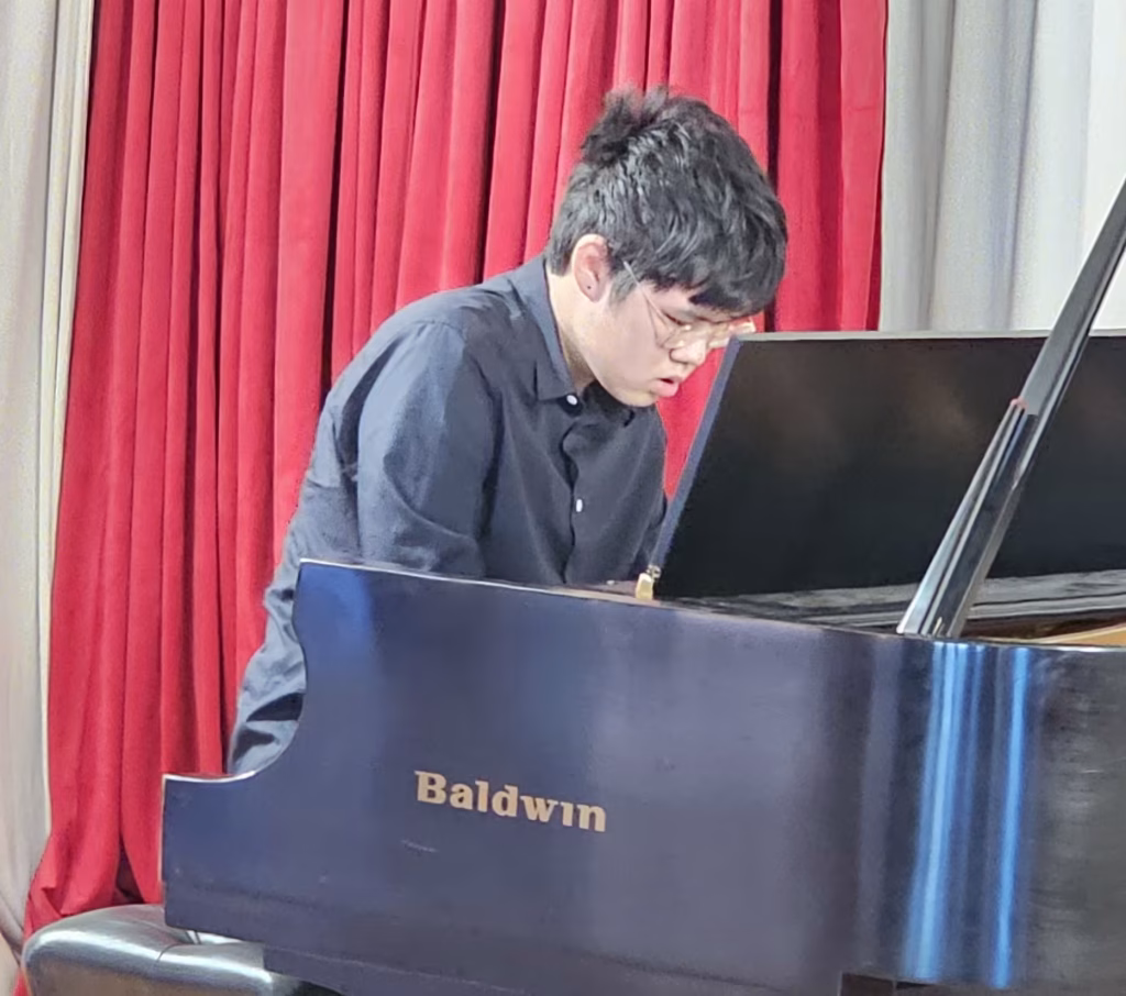 K&M Music School student focused on playing piano during a performance.