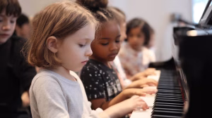 Two young children learning teamwork while playing piano together