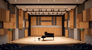 Modern recital hall with wooden acoustic panels and a grand piano on stage