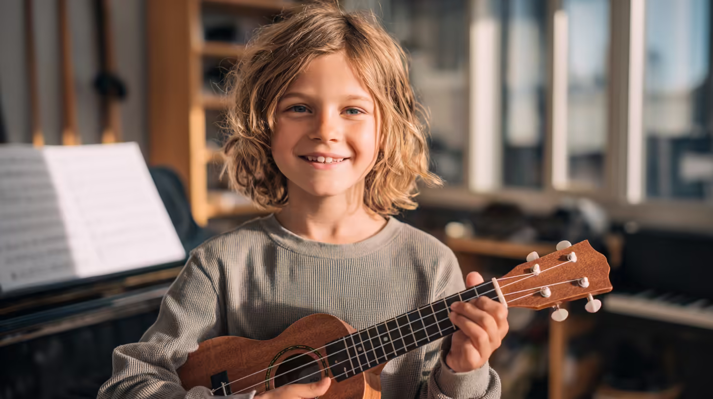 Kid holding ukulele