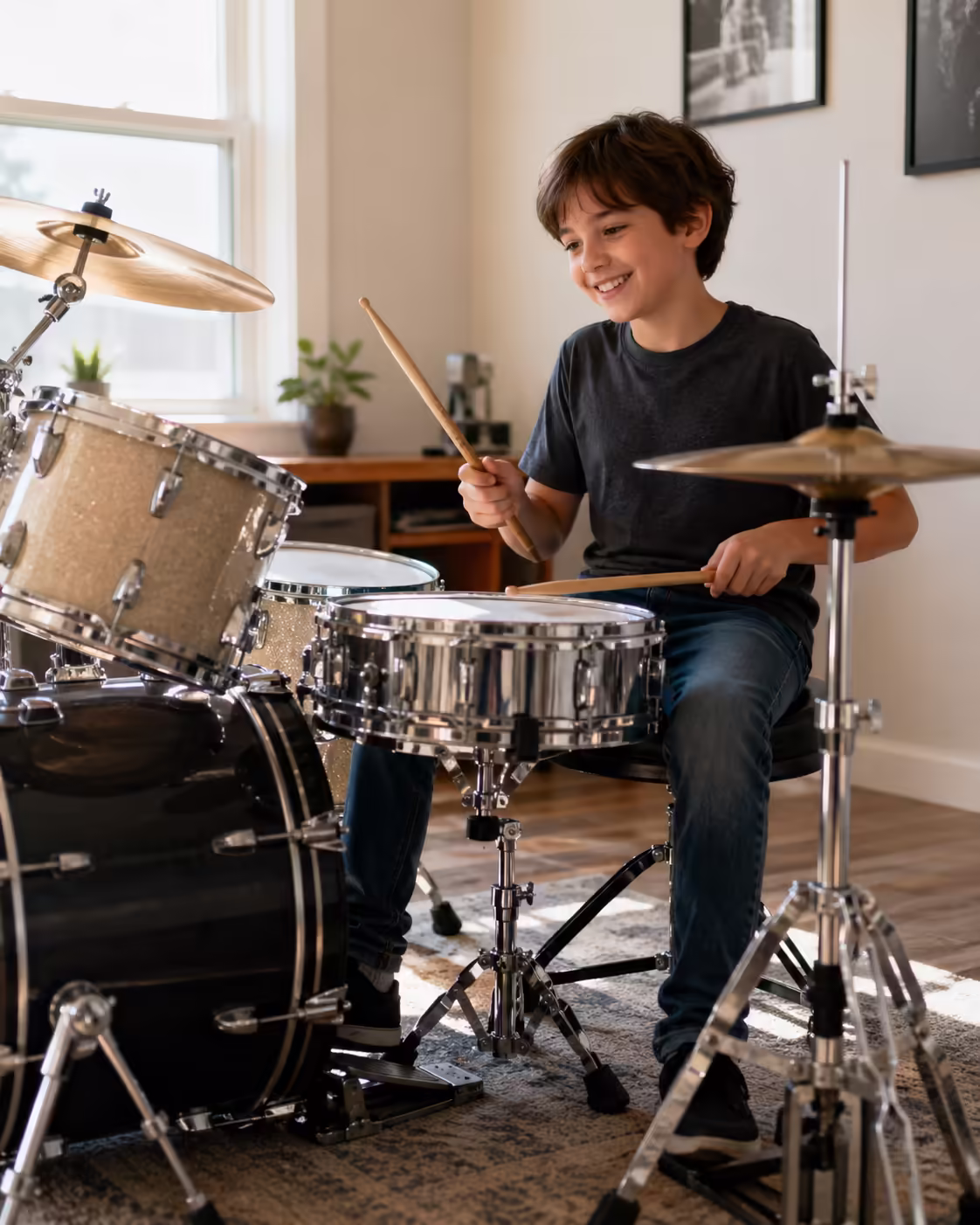 Young beginner playing an acoustic drum set