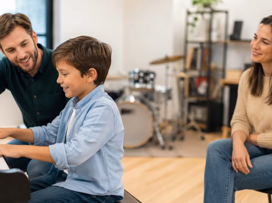 Parent and child meeting with a music teacher in a piano studio to discuss the best age to start music lessons.