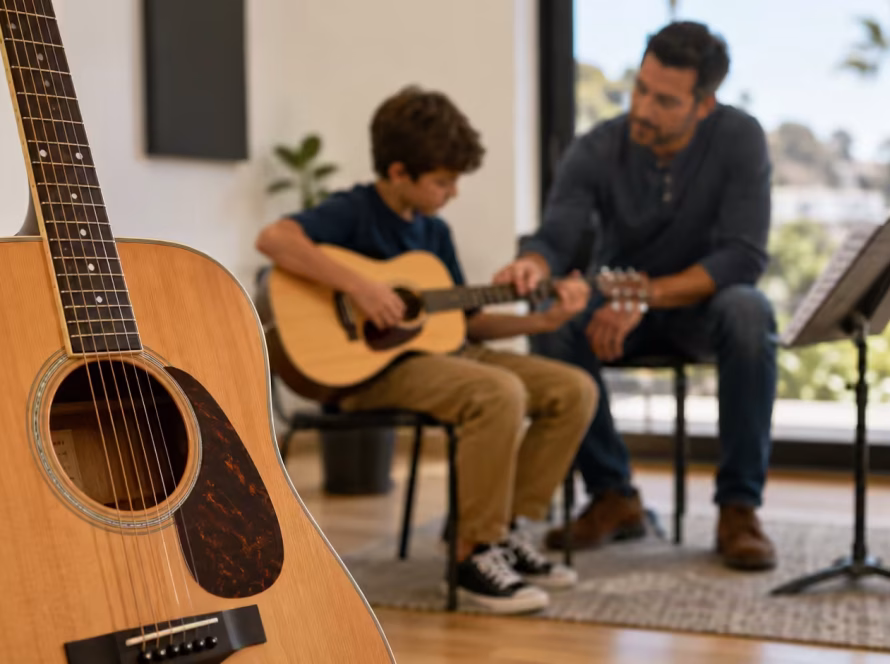 Acoustic guitar in focus with a private guitar lesson happening in the background in a San Diego music studio.