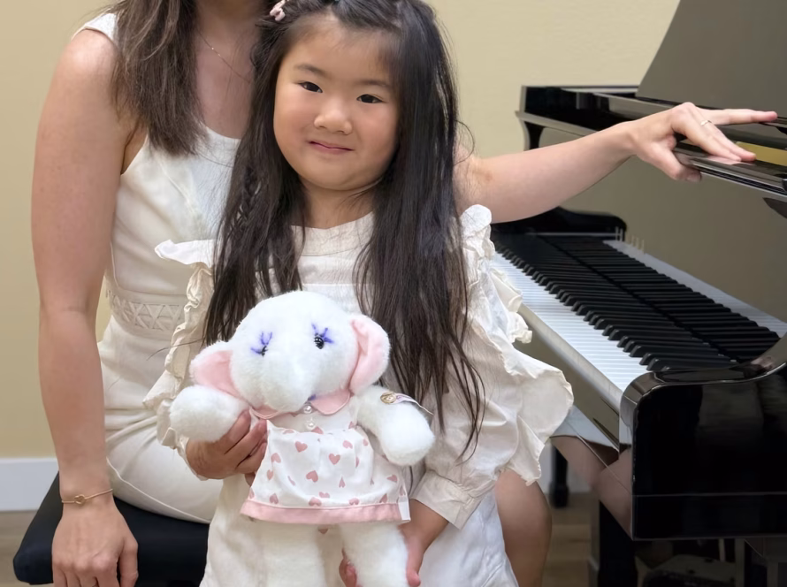 Piano teacher and young student smiling together after a private piano lesson at K&M Music School.