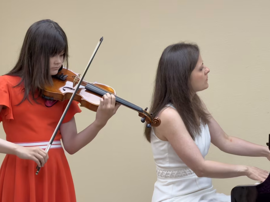 Violin student performing with a pianist at K&M Music School in San Diego.